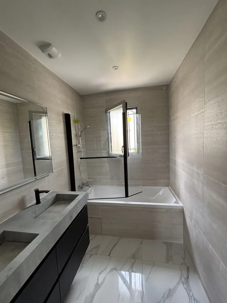 Salle de bain avec baignoire et paroi vitrée