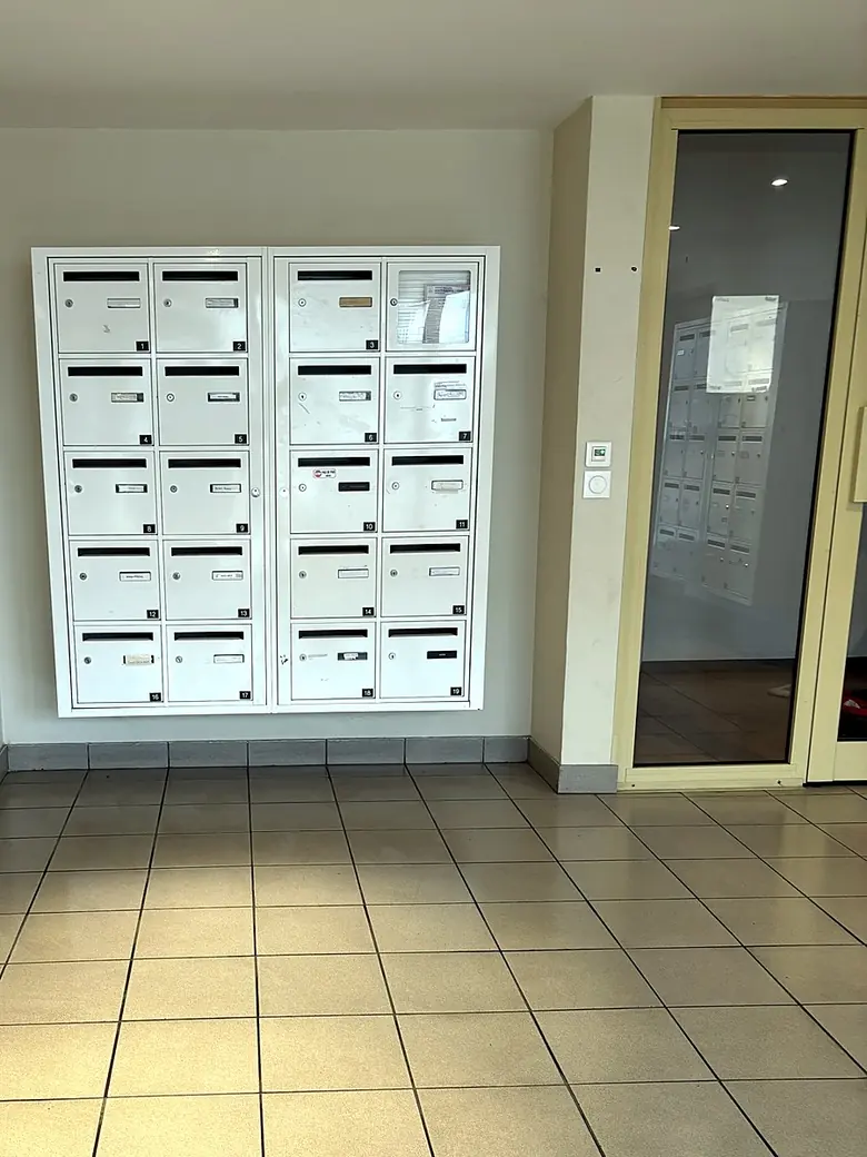 Boîtes aux lettres et sol carrelé d'un hall de copropriété entretenu par ALTIS